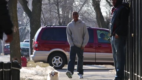 Chicago, Circa 2013: A young African/American man walks with swagger down city street in Chicago, Circa 2013. Street corner activity in a high crime area