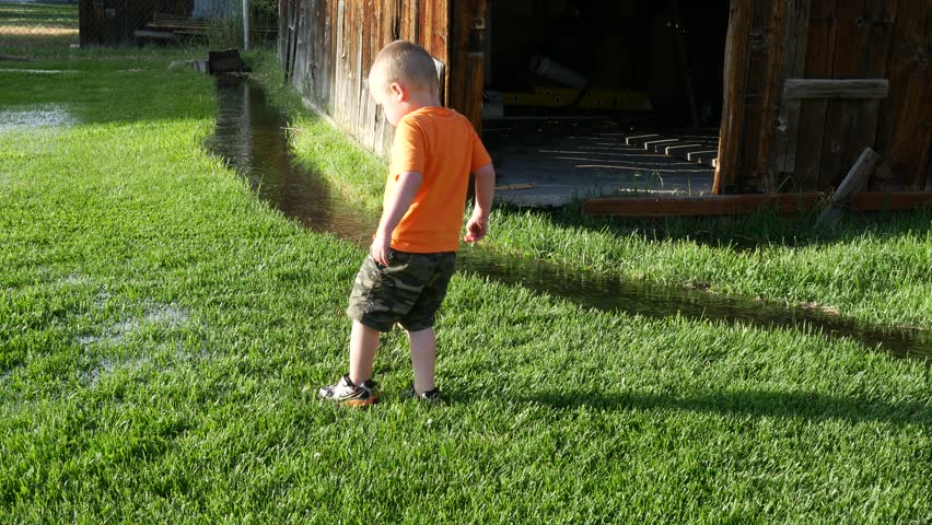 Children stomping around on the flooded wet grass. 