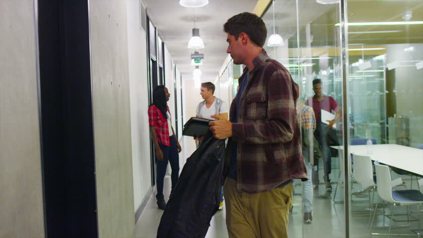 Young student group walking through the hallway in modern college building