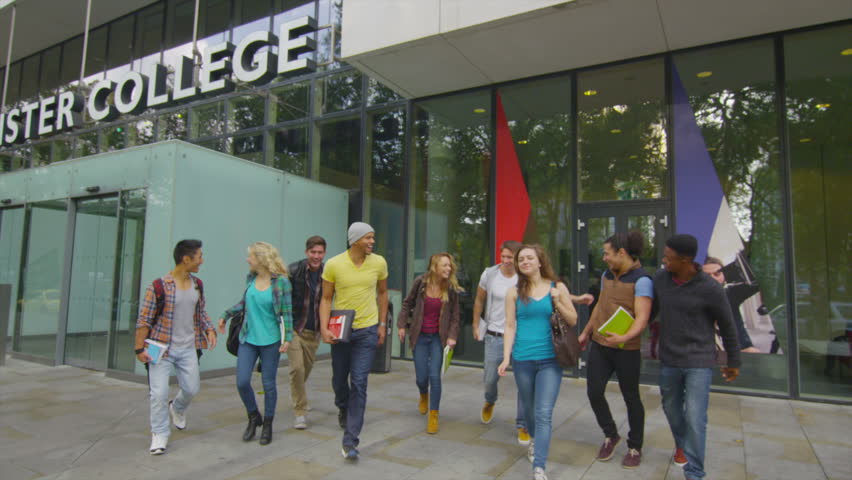 Portrait of cheerful diverse student group outside college building