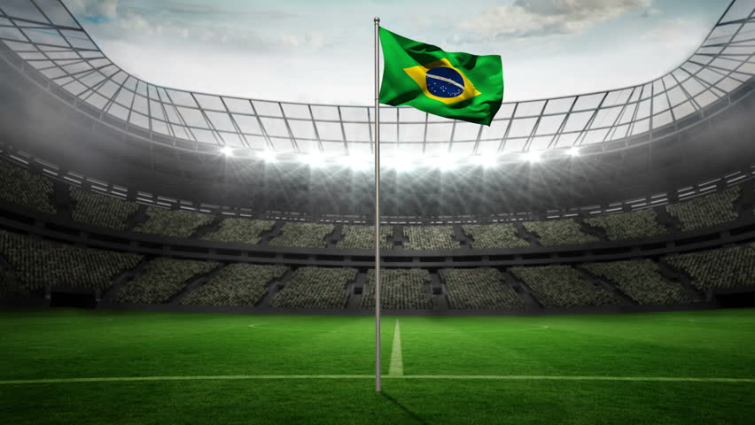 Brazil national flag waving on flagpole in football stadium with flashes