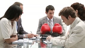 Stressed manager wearing boxing gloves in a meeting  - Powered by Shutterstock - Get 15% off with code: PIKWIZARD15