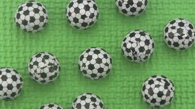 Close up of candy sweets in the shape of footballs rotating on a green background.