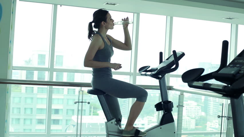 Woman drinking water during ride on stationary bike in gym
 | Shutterstock HD Video #6578423