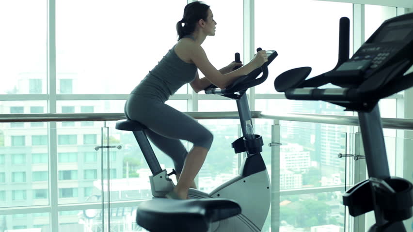 Young woman riding at stationary bike in the gym
 | Shutterstock HD Video #6578474