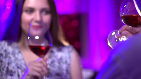 Young Couple Toasting Wine Glass In Restaurant. Dating. Young man and woman on romantic dinner drinking at restaurant, celebrating valentine day. Slow motion video 1080 full hd. High speed camera shot
