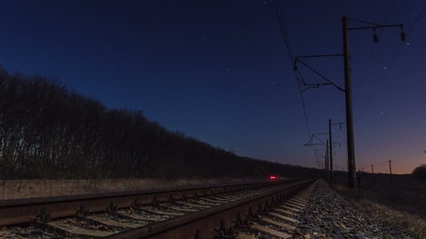 4K. Timelapse of a starry sky and rail track in the foreground