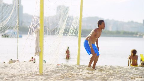 Brazilian man attempts to block a soccer goal.