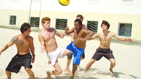 Friends compete to score a header at a beach