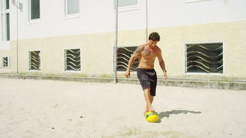 Friends practice soccer skills on a beach 