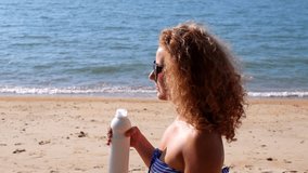 Young Woman Drinking Milk and Pouring It Over Her Curly Hair on the Beach. Funny Slow Motion Video.