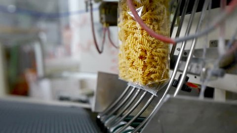Raw rotini scroodle fusilli envelopes in a pasta factory.