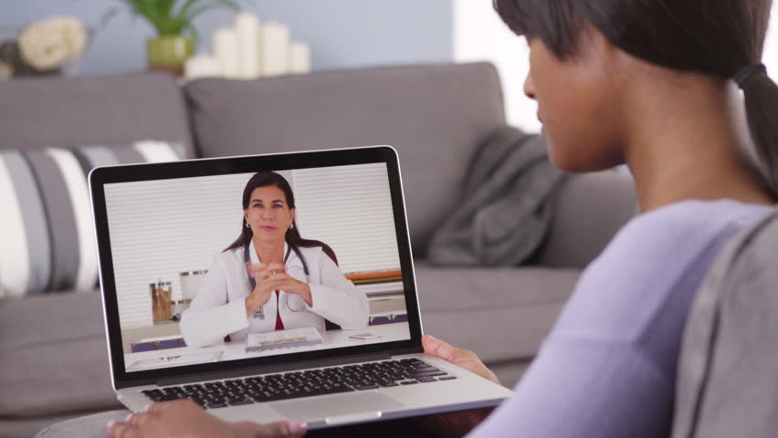 African woman video chatting with doctor. Tele medicine check up from home on laptop over the internet Royalty-Free Stock Footage #6599741