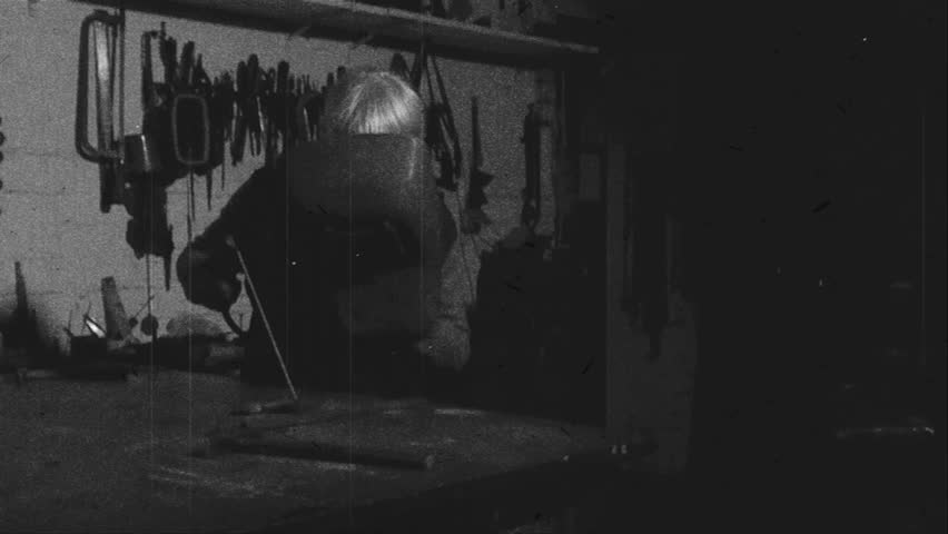 A worker welds - old film effect - black and white