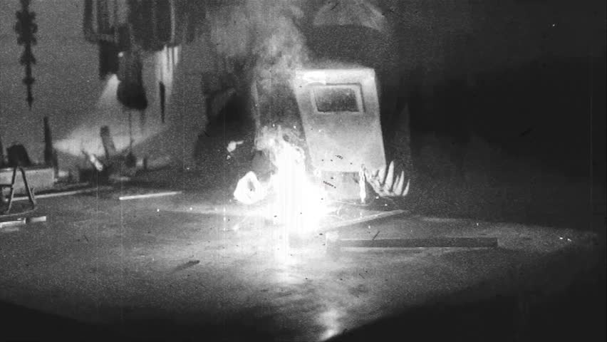 A worker welds - old film effect - black and white