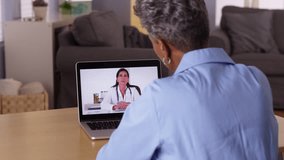 Mature African woman talking to doctor on laptop
