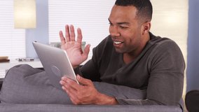 Black man video chatting on tablet