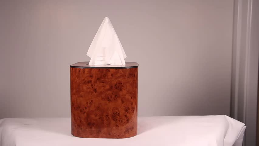 person pulling tissues from a tissue box