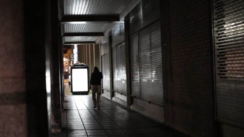 Man walking away in the city at night