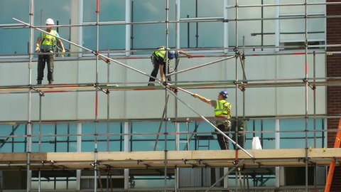 STAFFORD COLLEGE, STAFFORD, ENGLAND - 21ST JUNE 2014: Construction workers on scaffolding repairing a building time