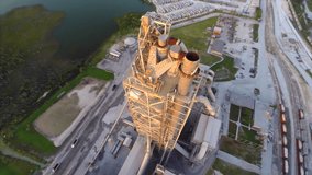 Aerial video of a smoke exhaust stack at an industrial excavation site