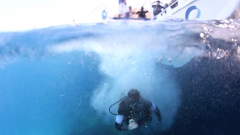 Scuba diver feet first entry into ocean