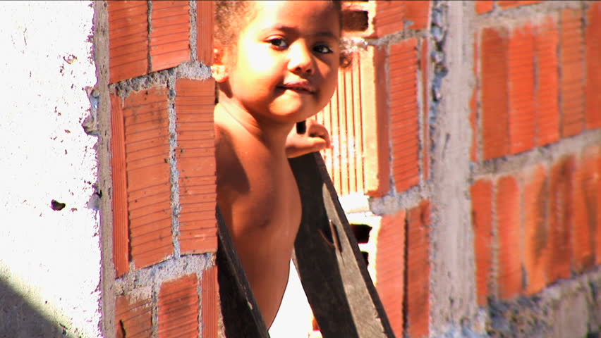 Rio de Janeiro - March 2014: Young inquisitive girl playing hillside favela poor Urban housing Rio de Janeiro Brazil South America