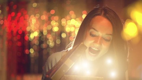 Beauty girl opens Christmas gift box with miracle lights. Surprised woman getting magic gift. Slow motion video footage 1080p. High speed camera shot 240 fps