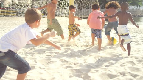 Kids playing soccer on a beach