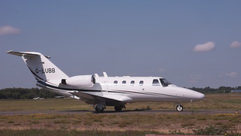Cessna Citation business jet holds short of runway at Blackbushe Airport, Hampshire, UK, June 2014, then taxis for take off.