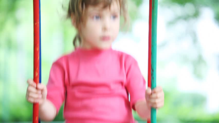 little girl blonde in pink t-shirt teeter in park close 