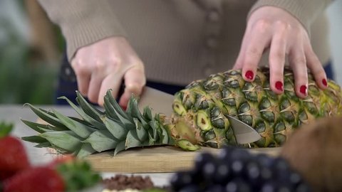 Slicing pineapple into slices in slow motion