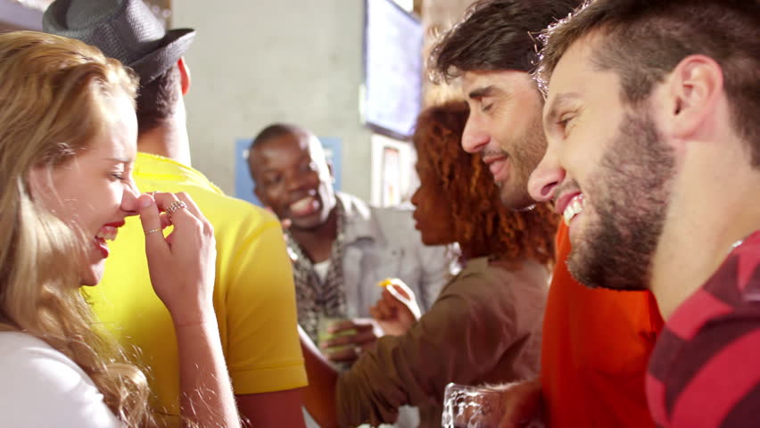 People Drinking and Talking at a Bar 