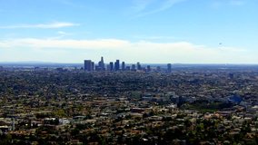 High and wide view of the Los Angeles city to downtown skyscrapers. This clip features the expanse of the city's populated looking landscape from a high vantage point. 