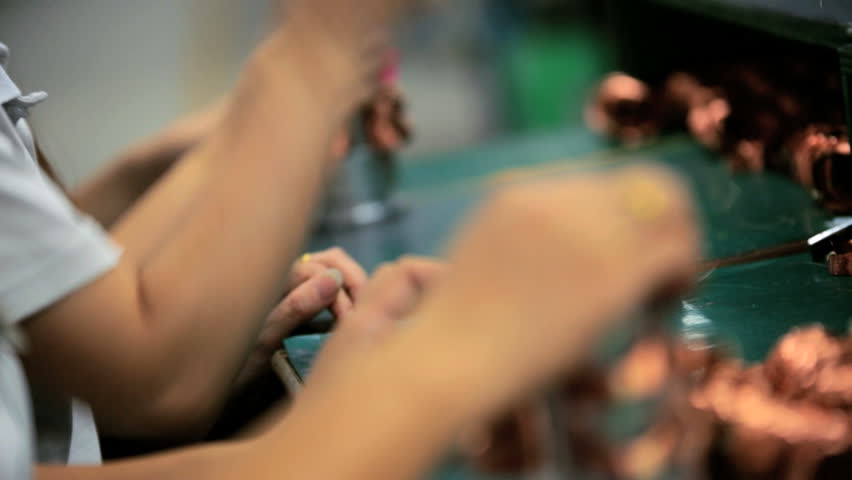 Close up view of assembly line workers producing electrical products for export, China, Time lapse