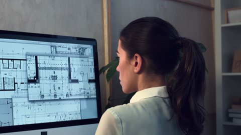 Woman working at home office architectural plans