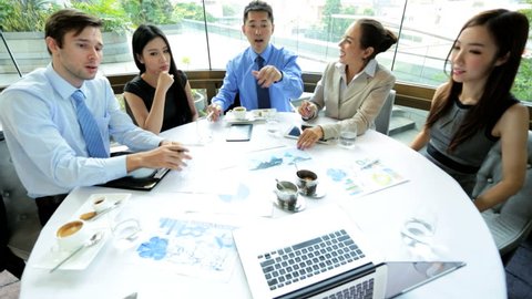 Ambitious male female Asian Chinese Caucasian business colleagues discussing future performance video conference wireless laptop restaurant