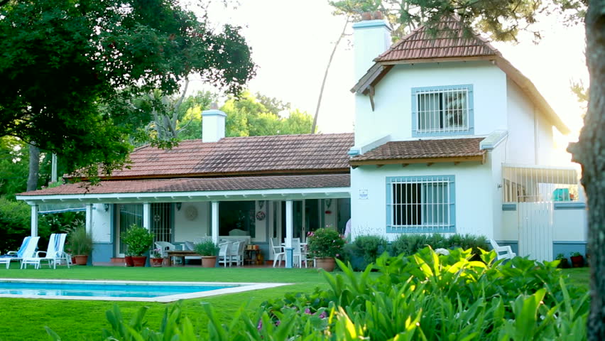 Shot of a home during golden hour / Establishing shot of ideal family home during sunset / Flare hitting the camera