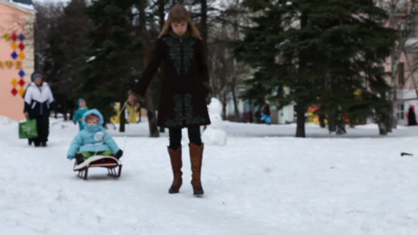 Mother carries the child on a sledge