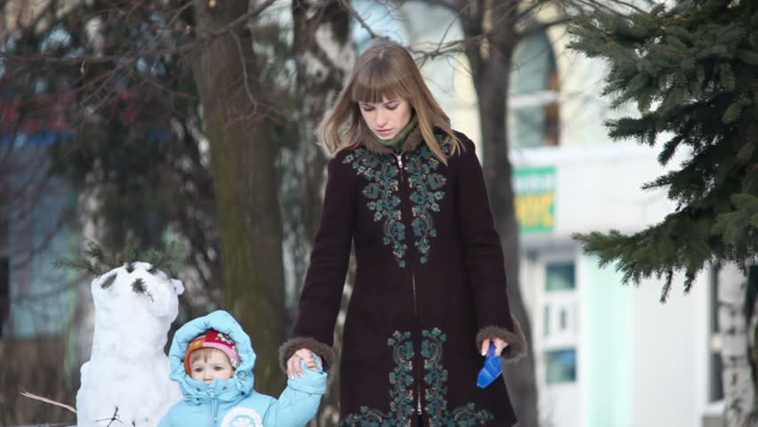 Mother and child walking in the park in winter.