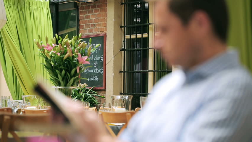 Blurred man sitting in restaurant, steadycam shot
