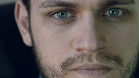 attractive young man with serious gaze looking into the camera: 4k footage