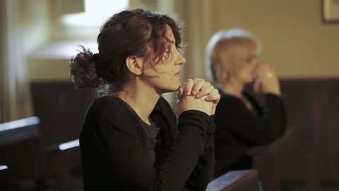 intense prayer of two women in a church: religion, faith, devotion, Catholics