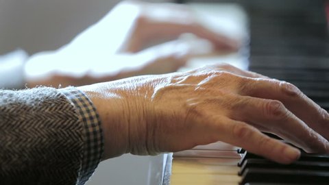 aged hands playing classical music at the piano: musician, arrangement, notes,