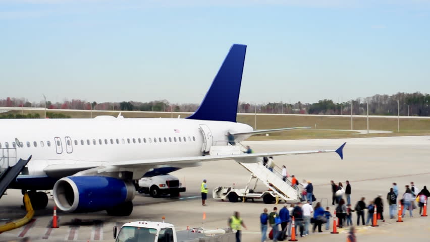 Time lapse shot of passengers boarding an airplane on the runway.