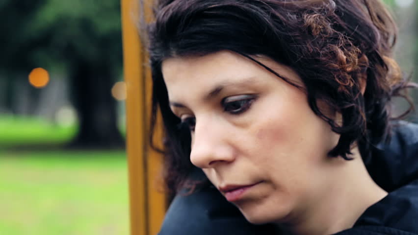 Sad woman with on swing in the park. Slowmotion