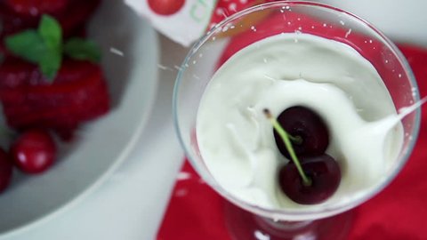 Cherry falling in yoghurt dessert, super slow motion, shot at 240fps
