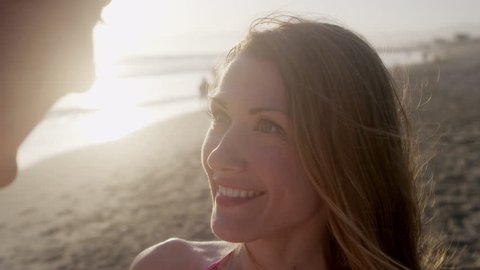 Beautiful Girl with Her Man on Beach at Sunset Kiss on Honeymoon Close Up in Slow Motion with Hair Blowing in Wind at Beach in 4K: film stockowy