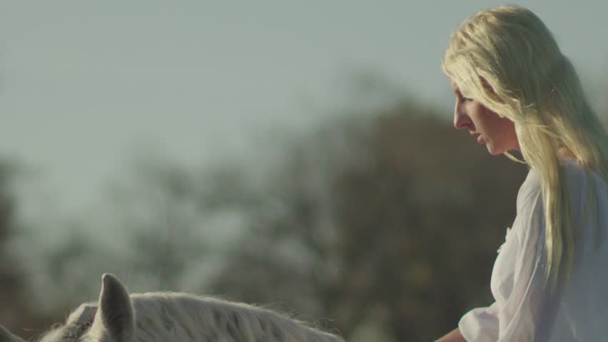 Young angel woman horseback riding in nature  