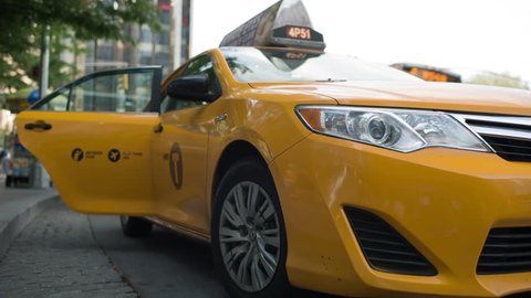NEW YORK - JULY 3, 2014: taxicab door closes and cab driving away at taxi stand, yellow cabs, Columbus Circle, NYC. Yellow cabs can pick up passengers anywhere in New York City's five boroughs. 
